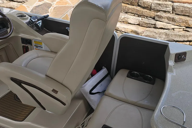 Slide: The Image of Captain's chair and seating area on 2015 Premier 310 Escalante boat, featuring cup holders. - 24