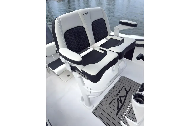 Slide: The Image of 2026 Tidewater 210 CC Adventure boat seating with armrests, featuring black and white upholstery. - 7
