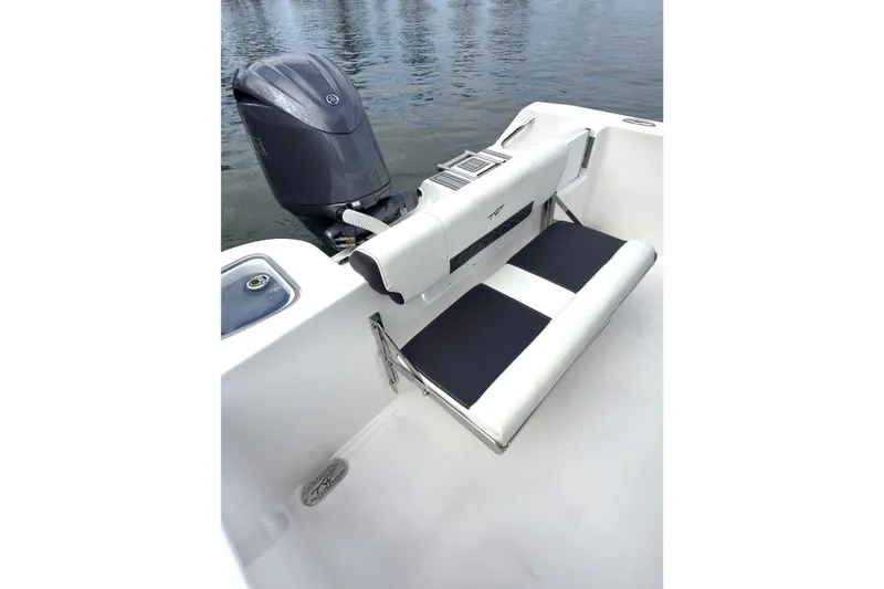 Slide: The Image of 2026 Tidewater 210 CC Adventure boat with outboard motor and seating, on calm water. - 9