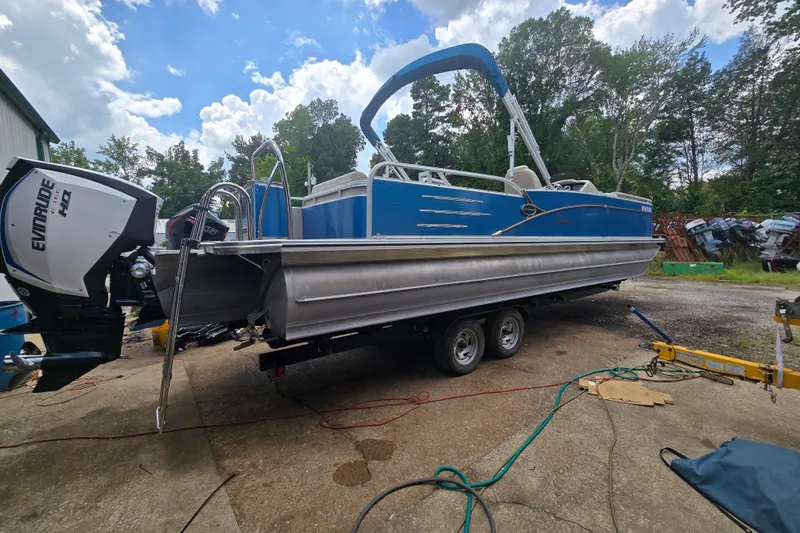 The Image of 2019 Avalon 2585 VRL pontoon boat with Evinrude engine on trailer, outdoors. - 1