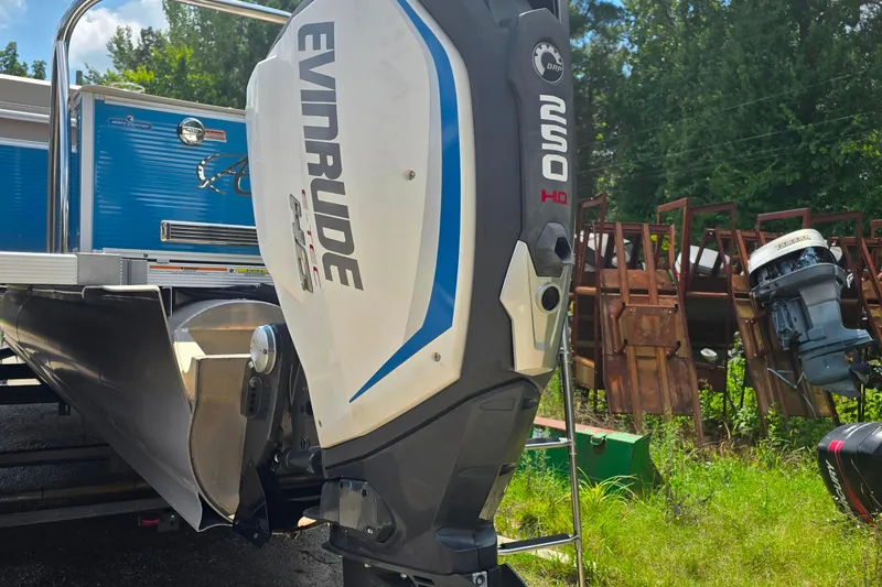 Slide: The Image of 2019 Avalon 2585 VRL boat with Evinrude outboard motor, parked outdoors. - 10