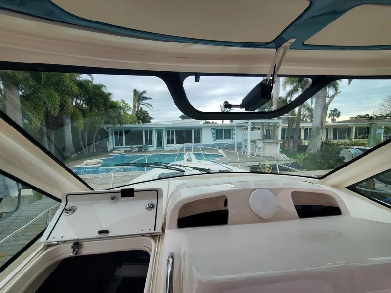 Slide: The Image of 2018 Grady-White Express 330 boat interior with helm and seating, docked by waterfront homes. - 34