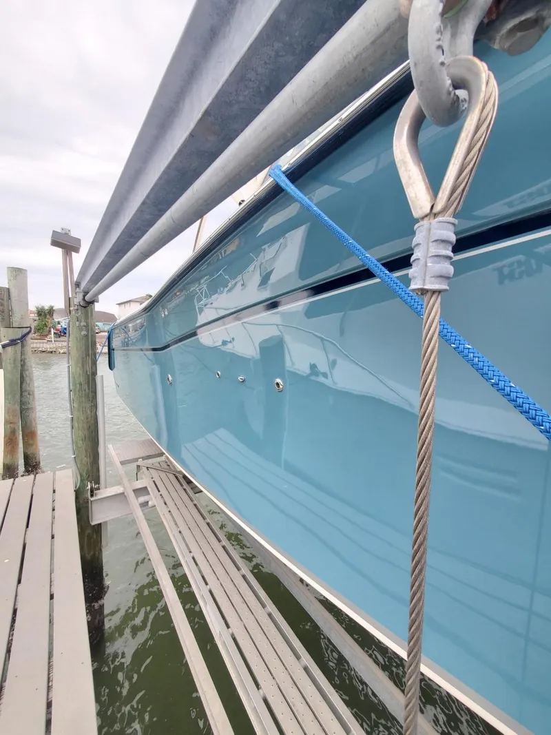 Slide: The Image of 2018 Grady-White Express 330 boat docked, featuring sleek blue hull design. - 4