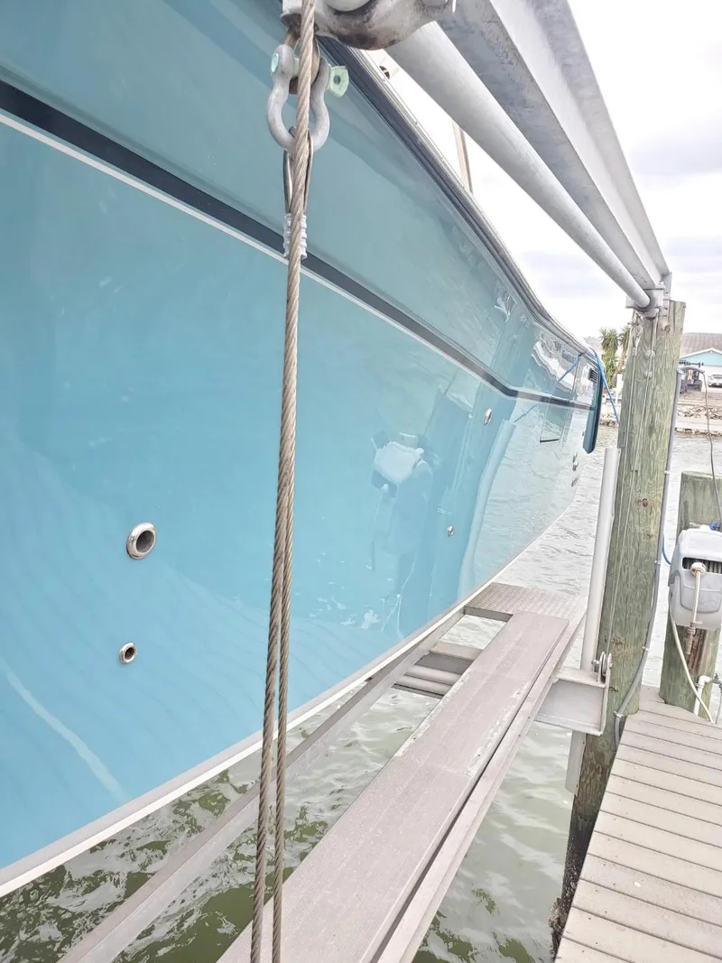 Slide: The Image of 2018 Grady-White Express 330 boat with blue canopy and sleek design against cloudy sky. - 7