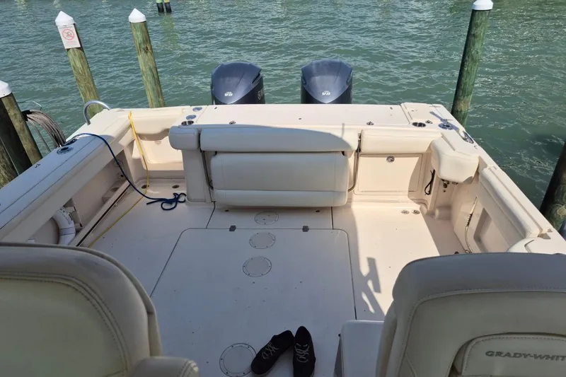 Slide: The Image of 2018 Grady-White Express 330 boat interior with twin engines at dock. - 75
