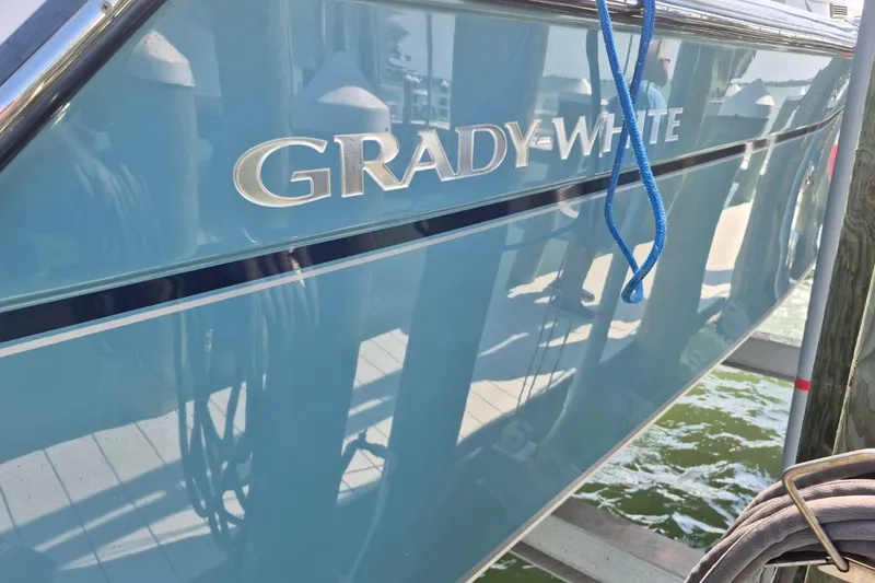 Slide: The Image of 2018 Grady-White Express 330 boat docked with blue hull and logo. - 81