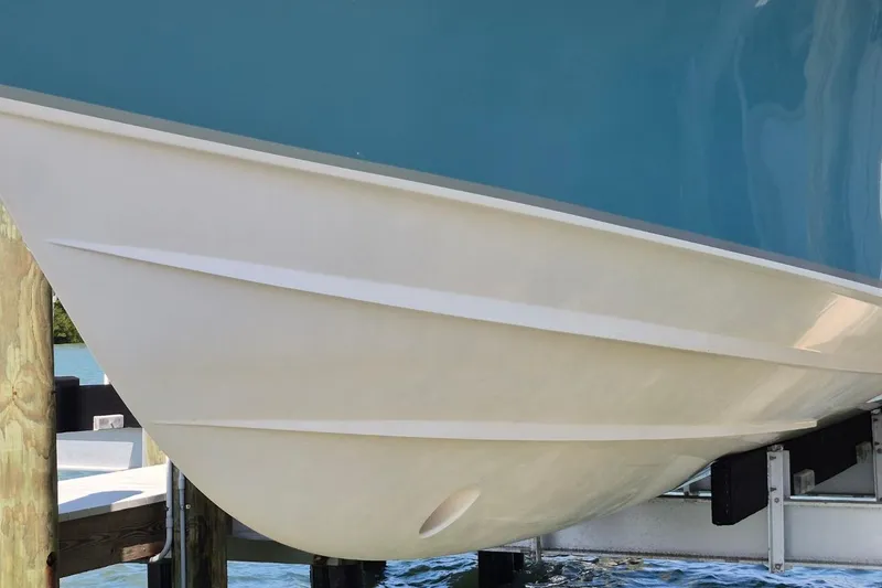 Slide: The Image of 2018 Grady-White Express 330 boat hull in dry dock, showcasing sleek design. - 85