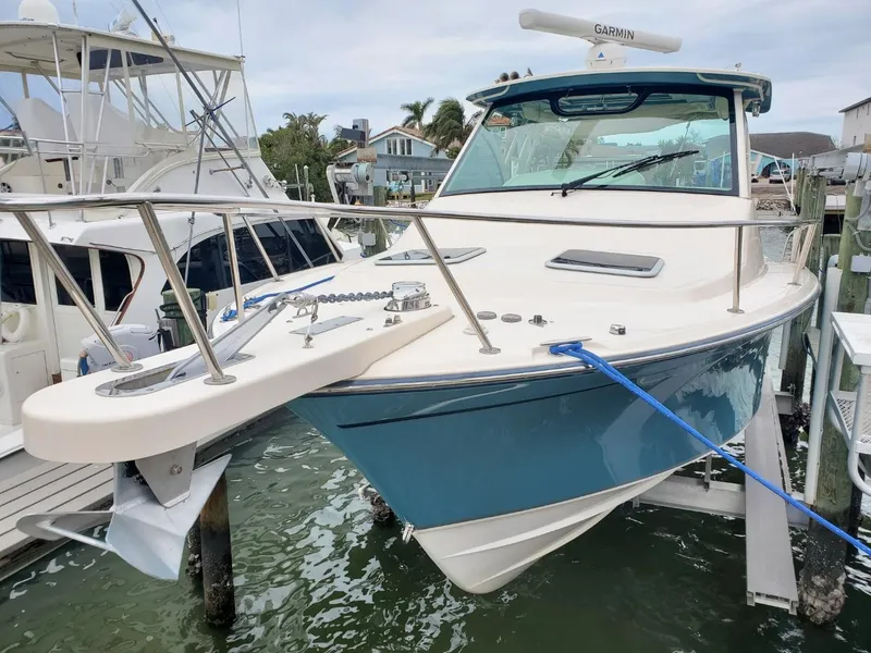 Slide: The Image of 2018 Grady-White Express 330 boat docked, featuring a sleek blue hull and modern design. - 9