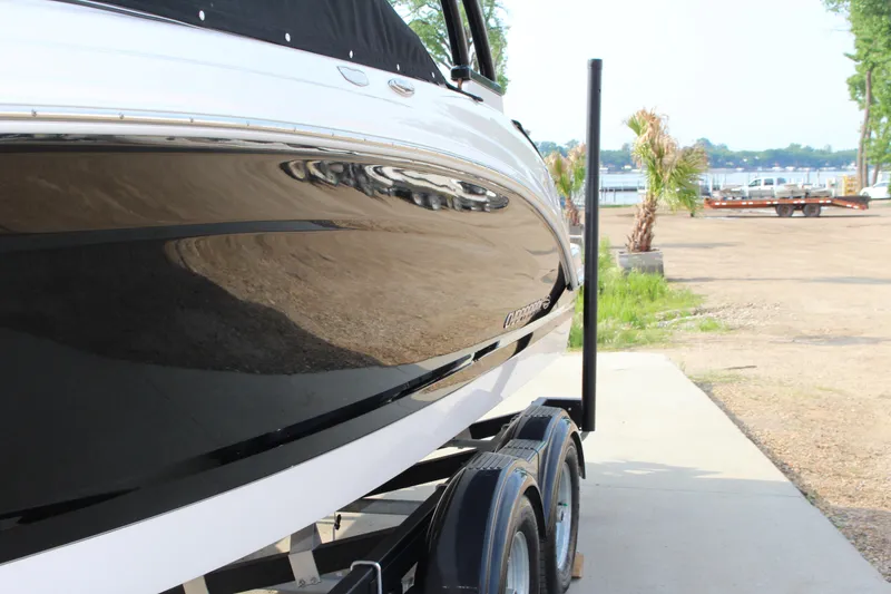 Slide: The Image of 2022 Chaparral 23 SSi boat on trailer, glossy black hull, outdoor setting. - 2