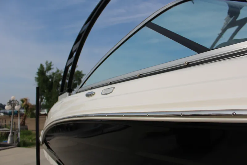 Slide: The Image of 2022 Chaparral 23 SSi boat, sleek design with tinted windshield, outdoor setting. - 3