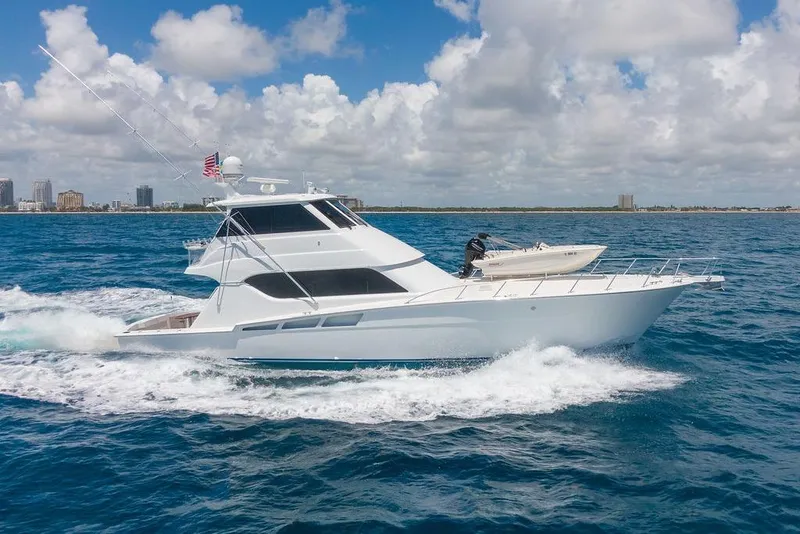 The Image of 2005 Hatteras Enclosed Bridge yacht cruising on blue ocean under cloudy sky. - 1