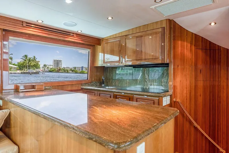 Slide: The Image of Luxurious 2005 Hatteras Enclosed Bridge yacht interior with elegant wood finishes and scenic window view. - 13