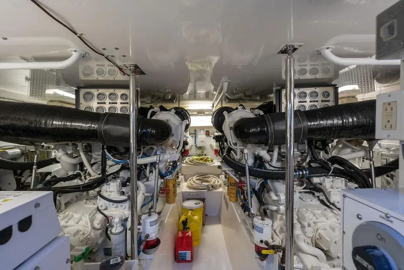 Slide: The Image of Engine room of a 2005 Hatteras Enclosed Bridge yacht, showcasing dual engines and control panels. - 29