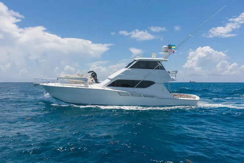 Slide: The Image of 2005 Hatteras Enclosed Bridge yacht cruising on open ocean under clear blue sky. - 3