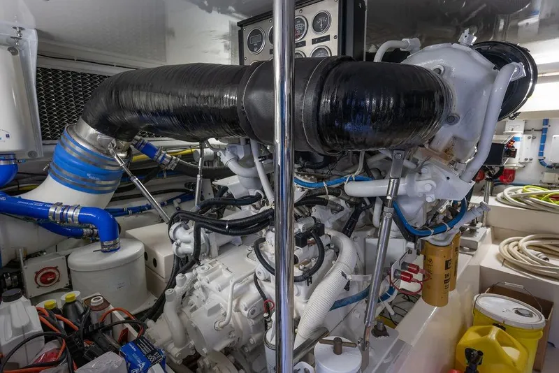 Slide: The Image of Engine room of 2005 Hatteras Enclosed Bridge yacht, featuring complex machinery and hoses. - 31