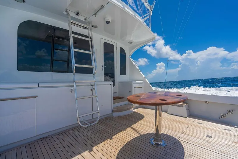 Slide: The Image of 2005 Hatteras Enclosed Bridge yacht deck with ladder, table, and ocean view. - 8