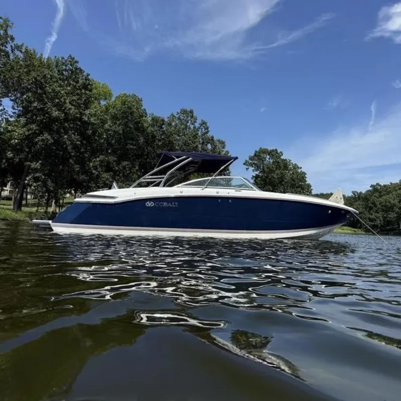 The Image of 2009 Cobalt 296 boat docked at marina with blue canopy and American flag. - 0