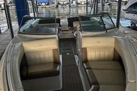 Slide: The Image of 2009 Cobalt 296 boat interior with beige seating, docked at a marina. - 3