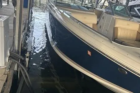 Slide: The Image of 2009 Cobalt 296 boat docked in marina, featuring sleek design and beige seating. - 6