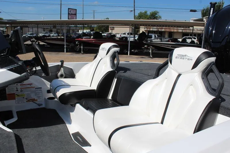 Slide: The Image of 2026 Skeeter ZXE20 boat interior with white seats and steering console. - 10