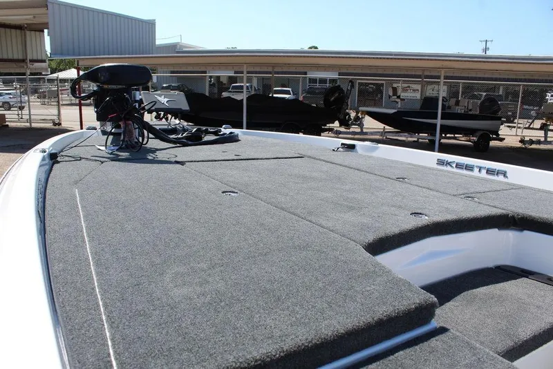 Slide: The Image of 2026 Skeeter ZXE20 boat deck with trolling motor, parked in a marina. - 15