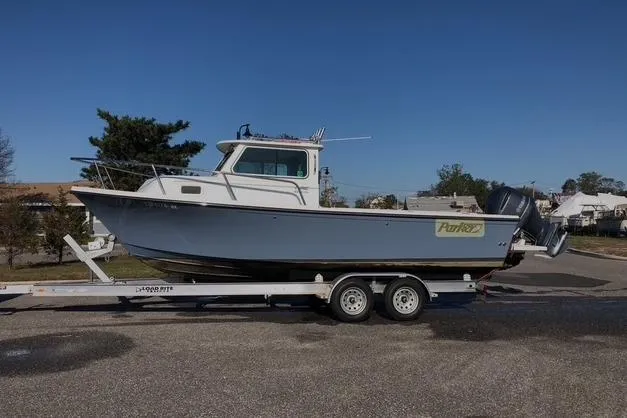 The Image of 2017 Parker 2320 SL Sport Cabin boat on trailer, parked outdoors. - 0