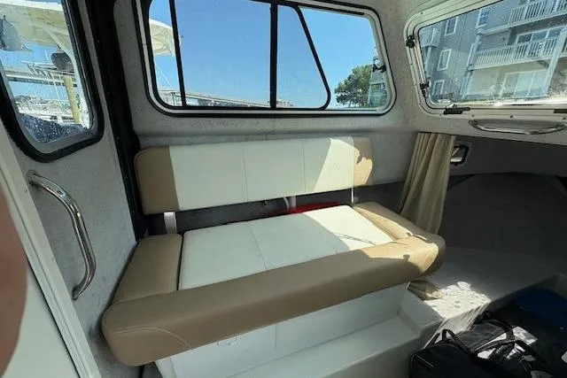 Slide: The Image of 2017 Parker 2320 SL Sport Cabin interior with cushioned seating and windows. - 2