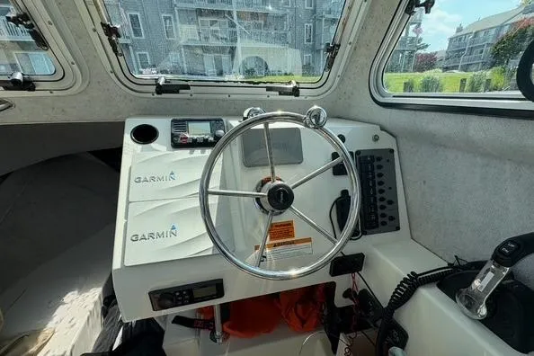 Slide: The Image of 2017 Parker 2320 SL Sport Cabin helm with Garmin navigation system and steering wheel. - 7