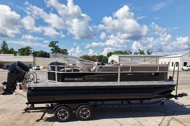 Slide: The Image of 2024 Ranger RP200C pontoon boat on trailer under a blue sky. - 1