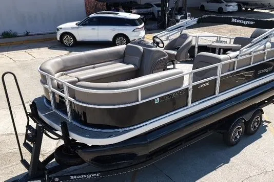 Slide: The Image of 2024 Ranger RP200C pontoon boat on trailer, parked in a lot. - 5
