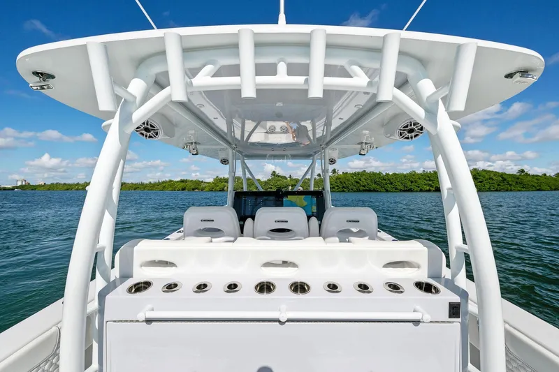 Slide: The Image of 2026 Contender 44 CB boat helm with seating, ocean view, and clear blue sky. - 16