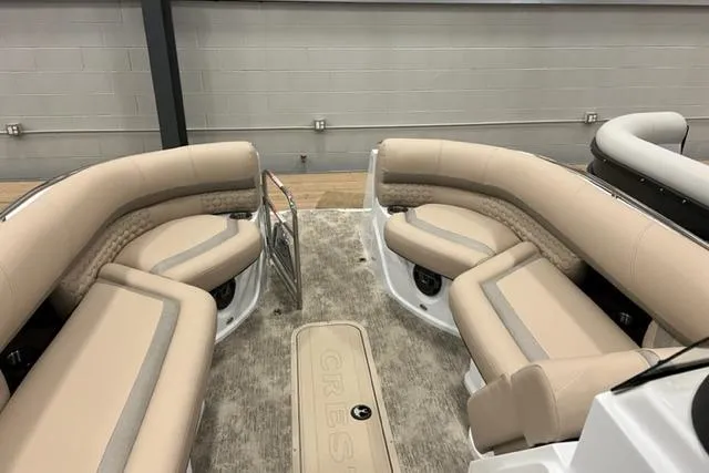 Slide: The Image of 2022 Crest Savannah 250 SLC boat interior with beige seating and carpeted flooring. - 4
