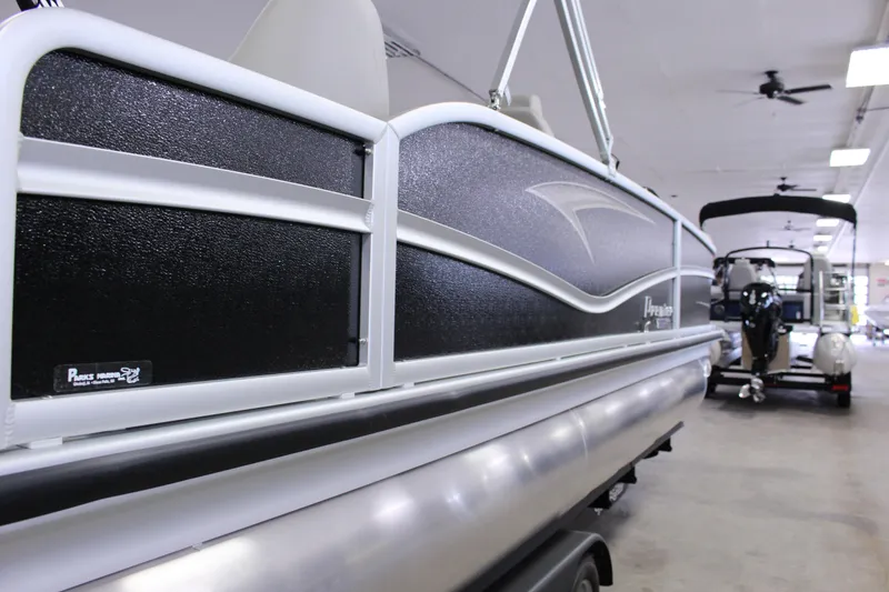 Slide: The Image of 2022 Premier 230 Explorer pontoon boat in showroom, side view. - 13