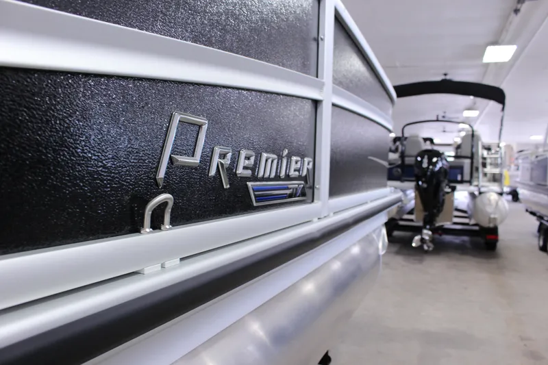 Slide: The Image of 2022 Premier 230 Explorer pontoon boat in showroom, close-up of logo and exterior. - 14