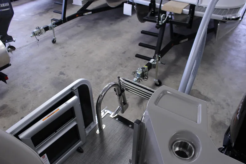 Slide: The Image of 2022 Premier 230 Explorer boat interior with ladder and trailer in garage setting. - 28