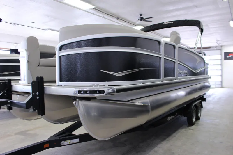 Slide: The Image of 2022 Premier 230 Explorer pontoon boat in a showroom, featuring sleek black and silver design. - 3