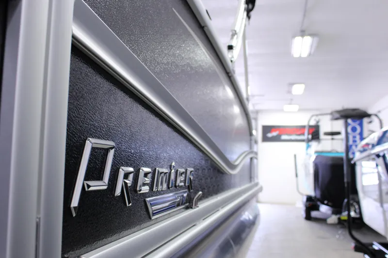 Slide: The Image of 2022 Premier 230 Explorer boat in showroom, close-up of logo and sleek design. - 5