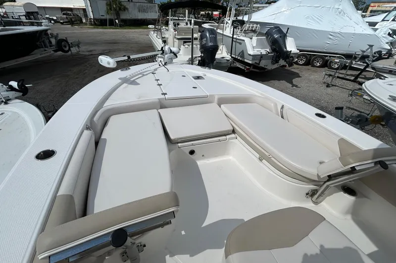 Slide: The Image of 2016 Robalo 246 Cayman boat interior with cushioned seating and fishing equipment. - 11