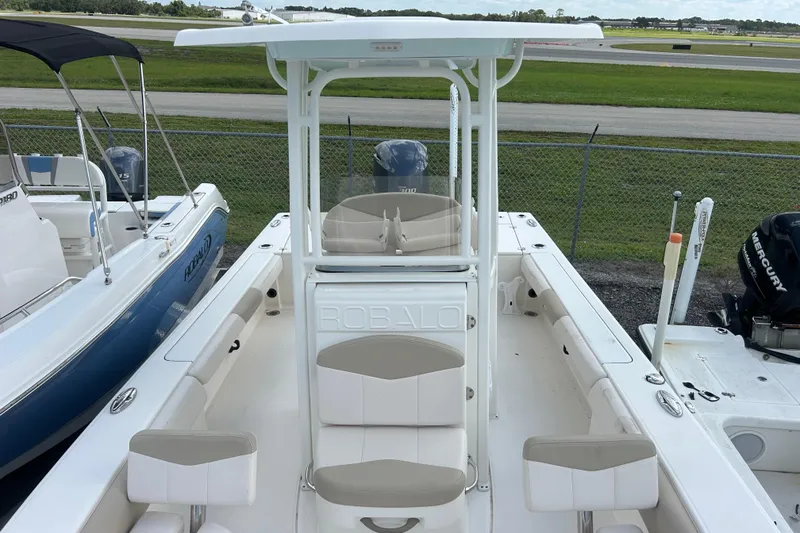 Slide: The Image of 2016 Robalo 246 Cayman boat with seating and console, docked near other boats. - 14