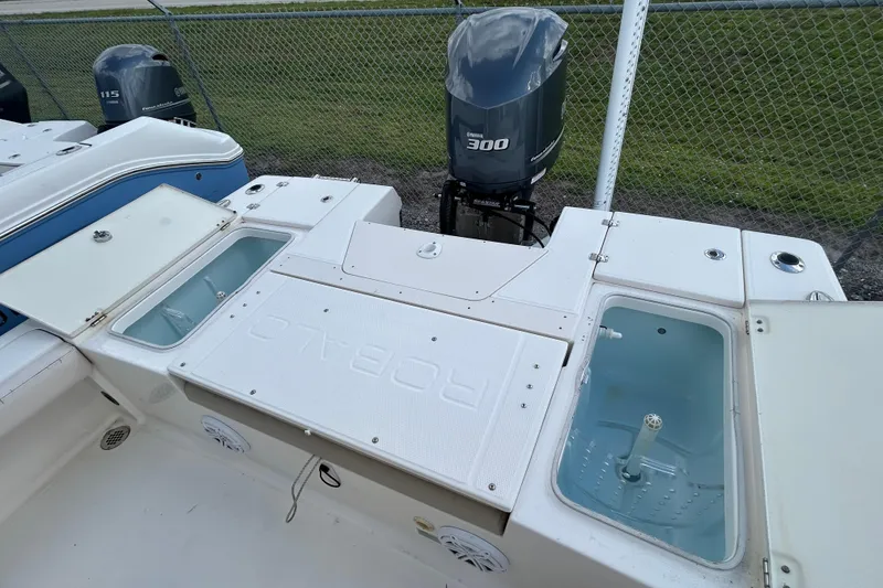 Slide: The Image of 2016 Robalo 246 Cayman boat with Yamaha 300 engine and open storage compartments. - 18