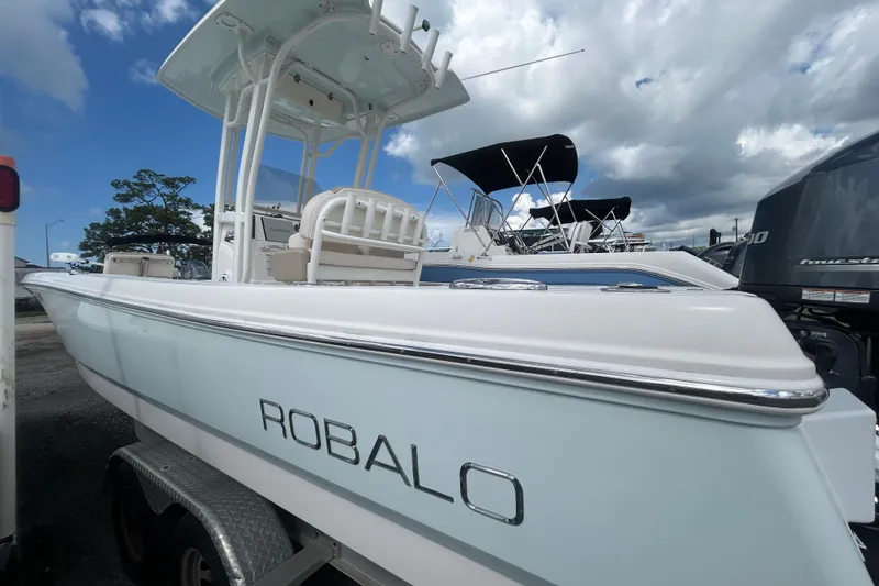 Slide: The Image of 2016 Robalo 246 Cayman boat on trailer under cloudy sky. - 3