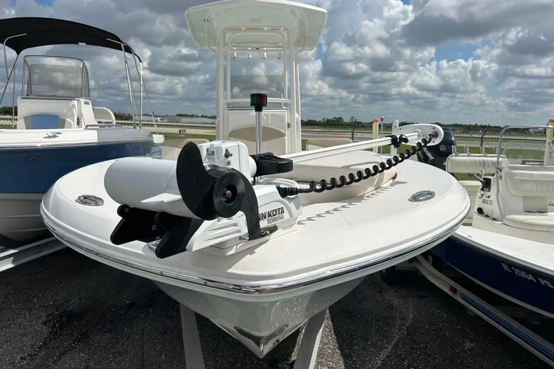 Slide: The Image of 2016 Robalo 246 Cayman boat with Minn Kota trolling motor, parked under cloudy sky. - 5