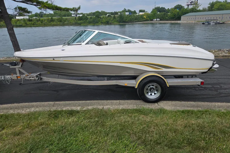 Slide: The Image of 2001 Tahoe Q5S I/O boat on trailer by a lakeside road. - 10