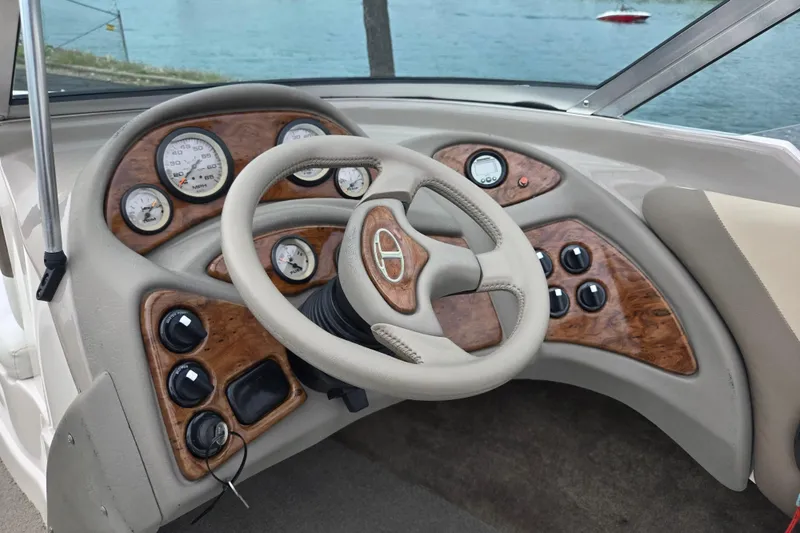 Slide: The Image of Steering wheel and dashboard of a 2001 Tahoe Q5S I/O boat by the water. - 15