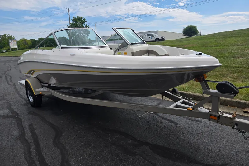 Slide: The Image of 2001 Tahoe Q5S I/O boat on trailer, parked on asphalt near grassy area. - 5