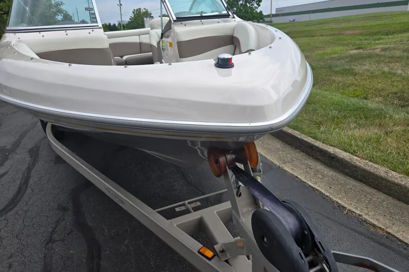 Slide: The Image of 2001 Tahoe Q5S I/O boat on trailer, parked on asphalt near grass. - 6