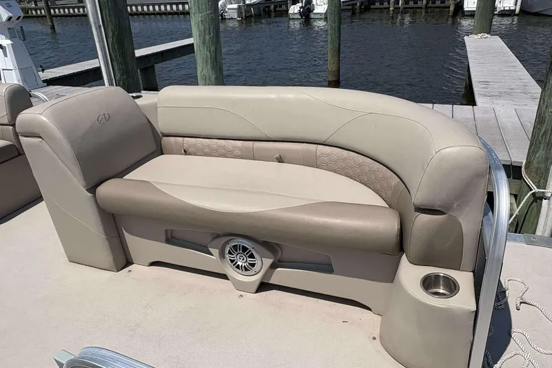 Slide: The Image of 2018 Avalon GS 2185 CR boat interior with beige seating and cup holder by the dock. - 15