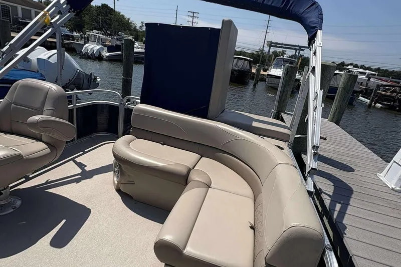 Slide: The Image of 2018 Avalon GS 2185 CR pontoon boat with beige seating at a marina dock. - 16