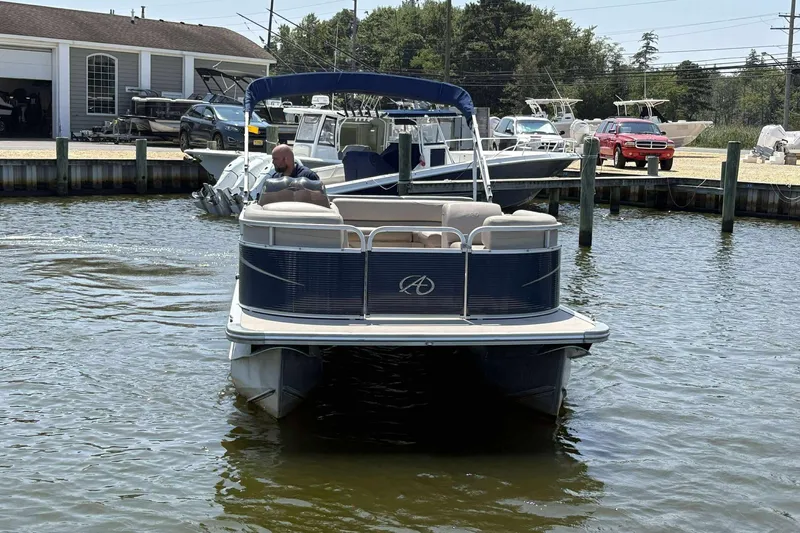 Slide: The Image of 2018 Avalon GS 2185 CR pontoon boat docked in a marina with surrounding boats. - 7