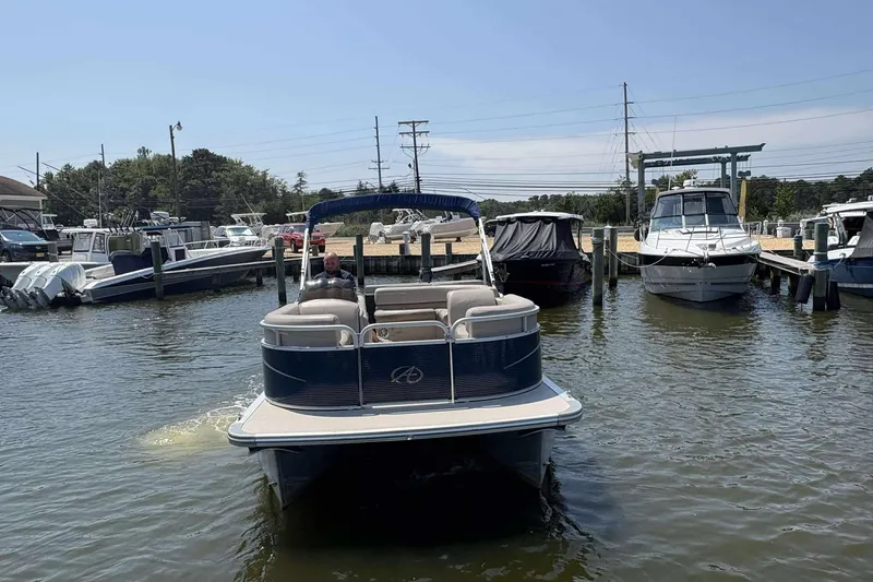 Slide: The Image of 2018 Avalon GS 2185 CR pontoon boat docked in a marina with other boats. - 8